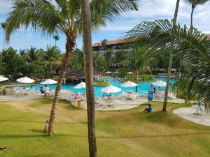 a resort with a swimming pool and palm trees at Flat Marulhos Resort in Porto De Galinhas