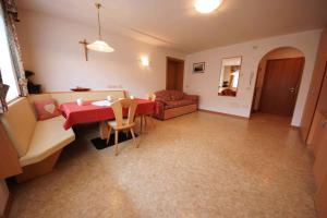 a living room with a red table and a couch at Residence Araldina in San Cassiano