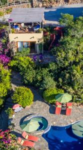 an aerial view of a pool with chairs and umbrellas at Los Colibris Casitas in Todos Santos
