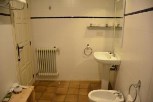 a white toilet sitting next to a sink in a bathroom at Posada Hoyos de Iregua in Villoslada de Cameros