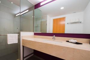 ein Bad mit einem Waschbecken und einem Spiegel in der Unterkunft La Quinta by Wyndham San Jose Chiapa Puebla in San José Chiapa