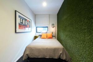 um quarto com uma parede em tons de verde e uma cama em Sale Street Loft em Auckland