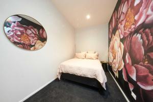 a bedroom with a bed and a mirror on the wall at Sale Street Loft in Auckland