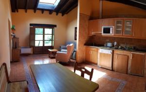 a kitchen and dining room with a table in a room at Amaicha Apartamentos Rurales in Ribadesella