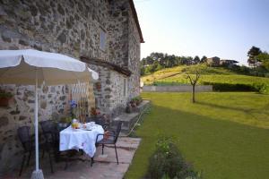 una mesa con sombrilla junto a un edificio en Casa Patrizia, en Borgo a Mozzano