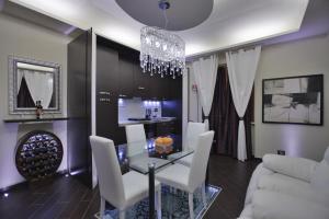 a dining room with a glass table and white chairs at EuroHome Comfort Apartment in Signa