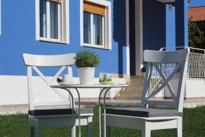 two chairs and a table in front of a house at Villa Le Garden in Nettuno