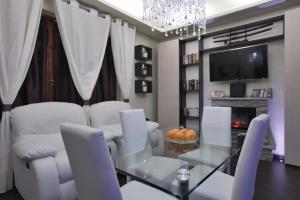 a dining room with a glass table and white chairs at EuroHome Comfort Apartment in Signa