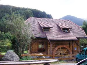 eine Blockhütte mit einem Dach darüber in der Unterkunft Pension Schlossbergblick in Simonswald