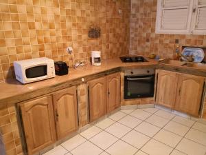 a kitchen with wooden cabinets and a microwave on the counter at Villa Josetta in Le François