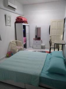 a bedroom with a large bed with a green blanket at Anis Homestay Kuala Perlis in Kuala Perlis