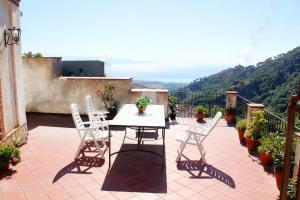 patio con mesa y sillas en el balcón en Villa Sarino, en Savoca