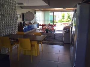 eine Küche und ein Esszimmer mit einem Tisch und Stühlen in der Unterkunft Bangalô luxo Carneiros Beach Resort in Praia dos Carneiros