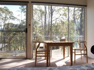a room with a table and chairs and a large window at Craggy Peaks Wilderness Cabins in Rossarden