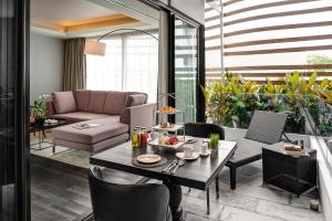Akyra Manor Chiang Mai SHA Extra Plus في شيانغ ماي: غرفة معيشة مع طاولة وأريكة