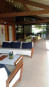een woonkamer met banken, tafels en stoelen bij Paraíso Malawí Flat Muro Alto in Porto De Galinhas