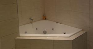 a bath tub in a tiled bathroom at 130 At The Waves in Cowes +20 photos