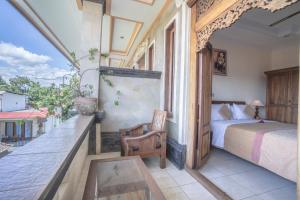 a bedroom with a bed and a table on a balcony at Ubud Sensasi Bungalow in Ubud