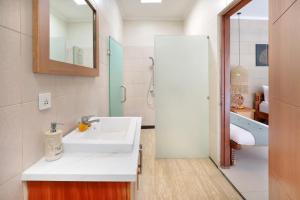 a white bathroom with a sink and a tub at The Vie Villa in Legian