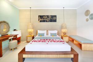 a bedroom with a large bed and a desk at The Vie Villa in Legian