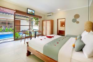 a bedroom with a large bed and a table at The Vie Villa in Legian