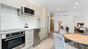 a kitchen and dining room with a table and chairs at Remarkables Garden 406 - Top Corner Unit - Super Convenient in Queenstown