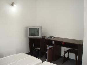 a bedroom with a desk and a tv on a desk at Pension Oasis in Costinesti