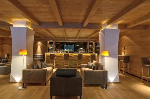 a living room with two couches and a bar at Stella Hotel - My Dolomites Experience in Selva di Val Gardena