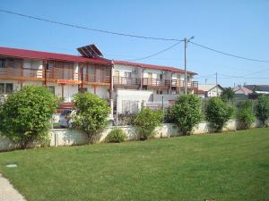 an apartment building with a lawn in front of it at Pension Oasis in Costinesti