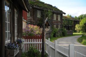 una cerca blanca frente a una casa con flores en Saga Trollheimen Hotel en Rindal