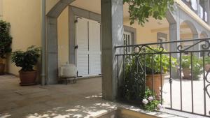 a porch of a house with a gate and potted plants at Apartmani More in Sveti Stefan