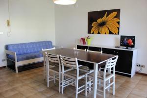 comedor con mesa, sillas y sofá en Appartamenti Oscar, en Grado