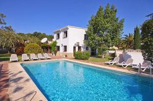 a swimming pool with chairs and a house at Villa Escocia in Jávea