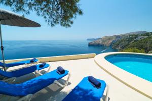 una piscina con sillas y vistas al océano en Villa Bombon, en Jávea