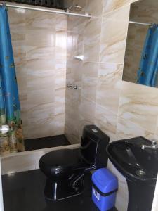 bagno con servizi igienici neri e lavandino di Hostal Sueños a Lima