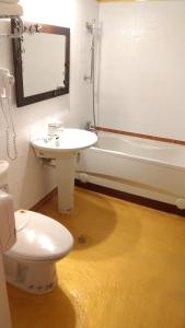 a bathroom with a toilet and a sink and a tub at Aloha Hotel in Keelung