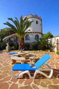a group of lounge chairs and a building with a palm tree at Casa Resa in Jávea