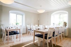 a dining room with white tables and chairs at Fredriksborg Hotell & Restaurang in Värmdö
