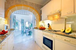 a large kitchen with white cabinets and a table at Casa Resa in Jávea