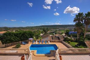 a resort with a swimming pool and palm trees at Villa Cora in Jávea