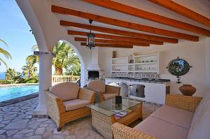 sala de estar al aire libre con cocina y piscina en Villa Lau, en Denia