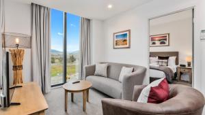 a living room with a couch and a bed at Remarkables Garden Apartment 305 in Queenstown