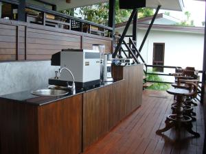 a kitchen with a counter with a coffee maker on a balcony at Chintakiri Resort in Ko Tao