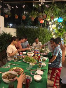 um grupo de pessoas sentadas à mesa a comer em An Thinh Homestay em Hoi An