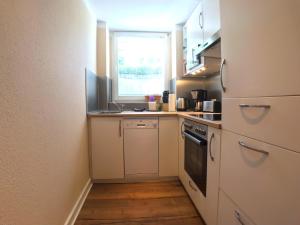 a small kitchen with a sink and a stove at Amaroo - Apartments Potsdam “Alexandrowka” in Potsdam
