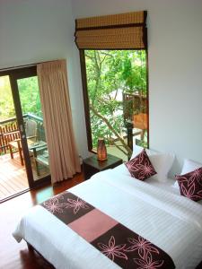 - une chambre avec un lit et une grande fenêtre dans l'établissement Chintakiri Resort, à Koh Tao