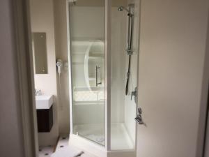 a shower with a glass door in a bathroom at Royal Mail Hotel in Lumsden