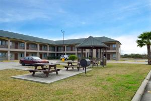 un parque con mesas de picnic y un cenador frente a un edificio en Econo Lodge Inn & Suites Port Arthur near Sabine Pass, en Port Arthur