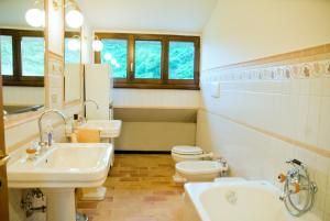 a bathroom with two sinks and a toilet and a mirror at Mimì e Cocò Country House in Ascoli Piceno