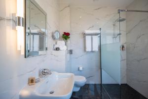 a white bathroom with a sink and a toilet at Hotel Carlton in Beaulieu-sur-Mer +21 photos